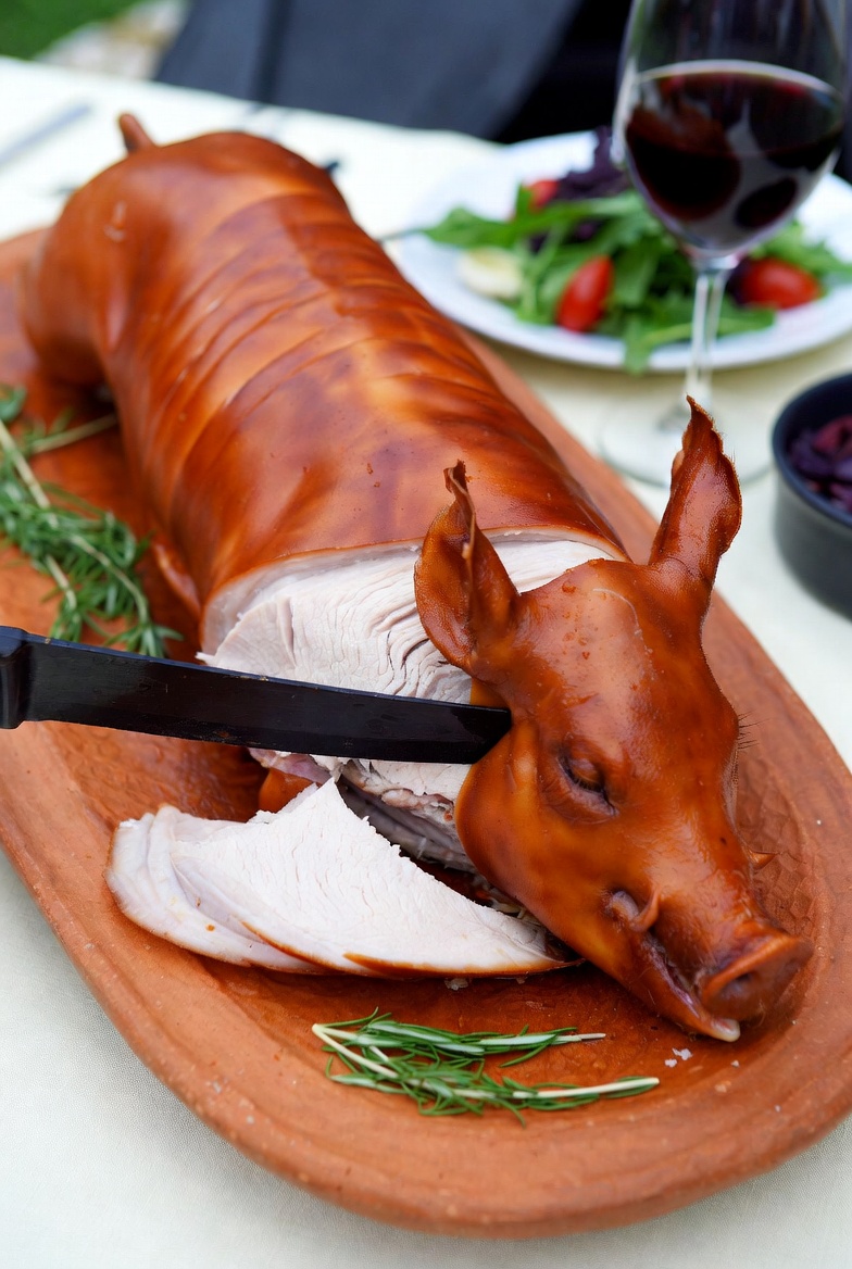 Cochinillo asado segoviano perfecto, servido en fuente tradicional.