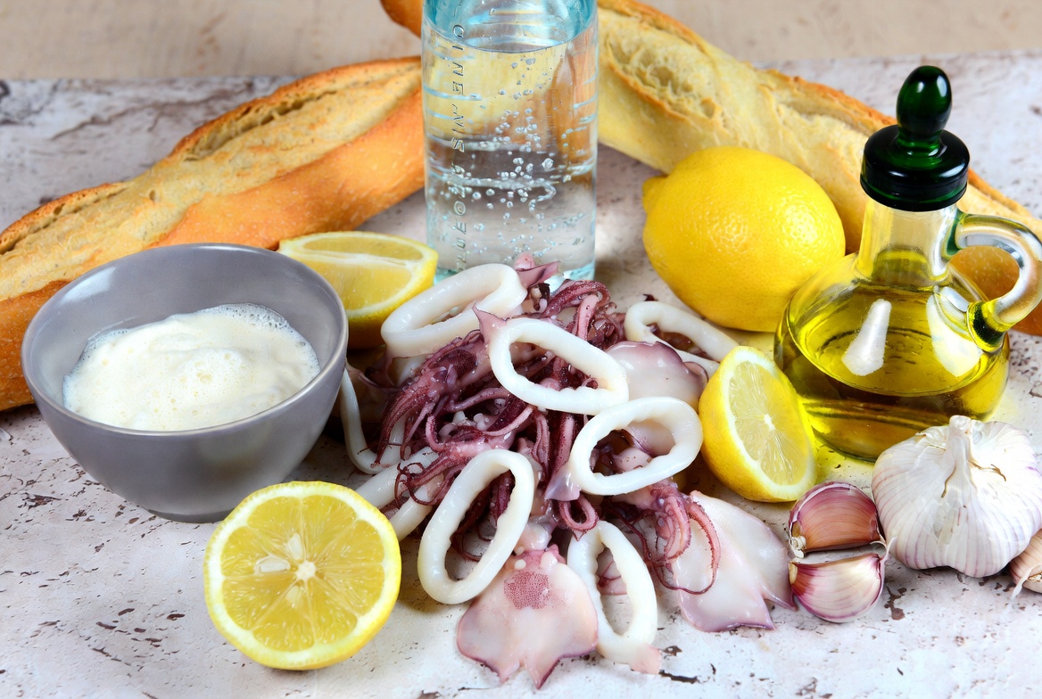 Ingredientes frescos para hacer mini bocadillo de calamares casero: calamares, pan, lim&oacute;n y especias
