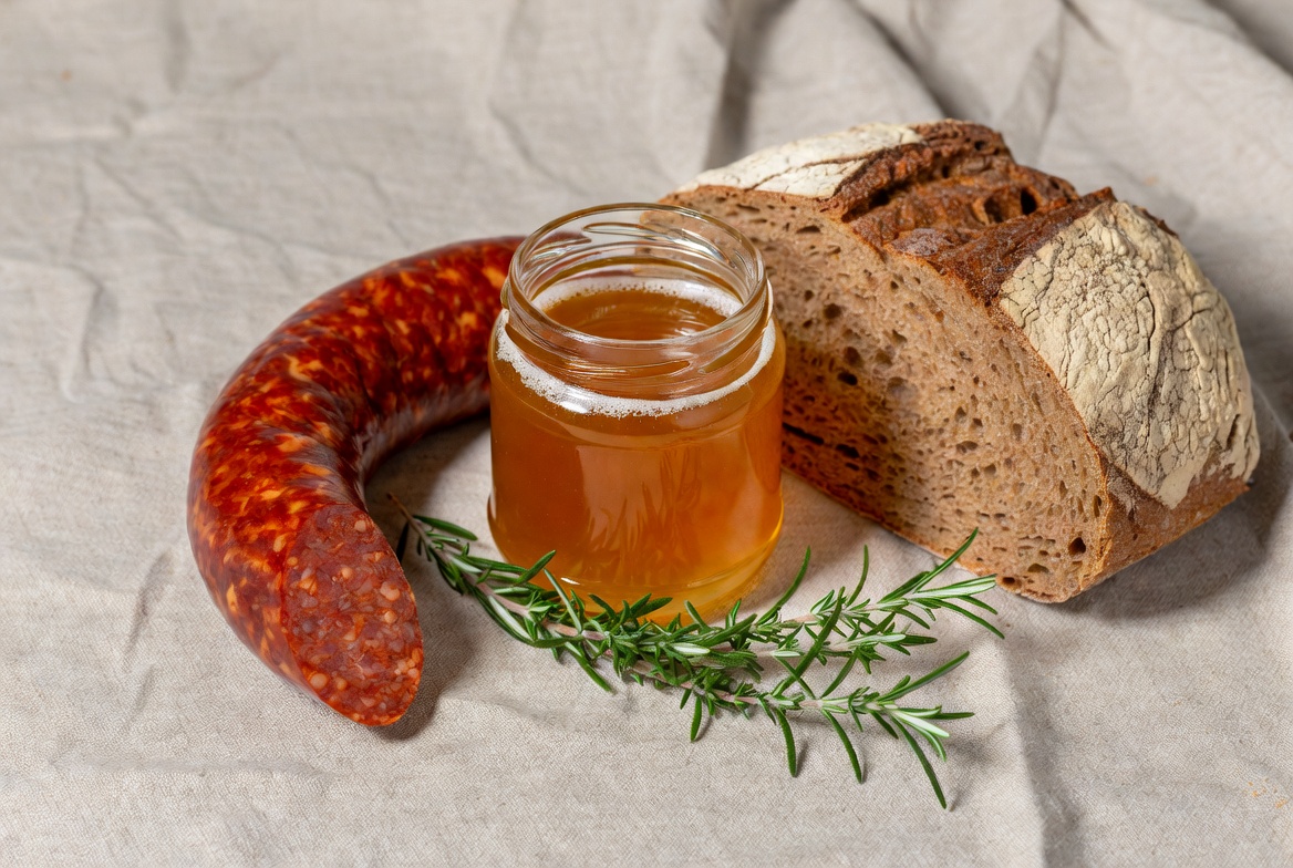Ingredientes para sobrasada con miel: embutido, tarro de miel y pan r&uacute;stico.