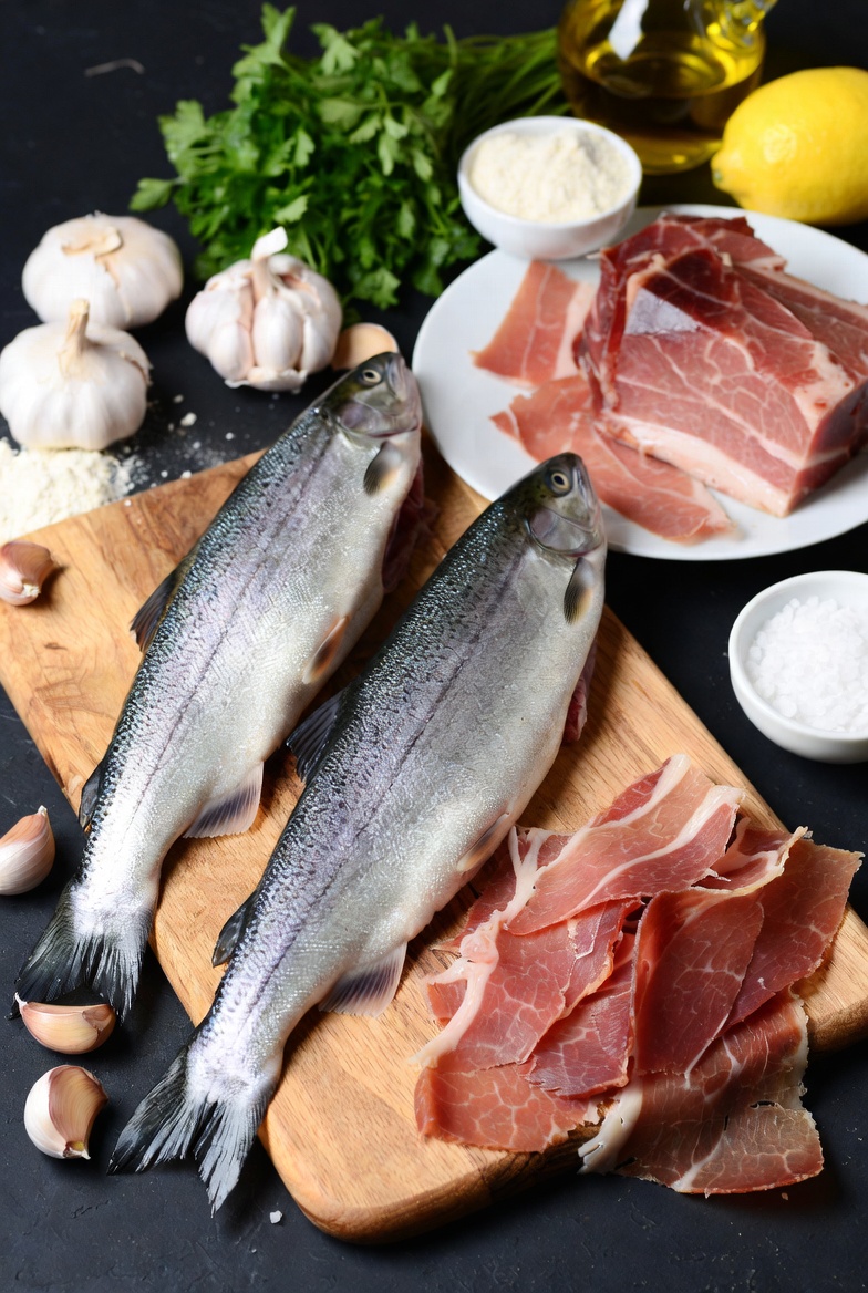 Ingredientes frescos para preparar la trucha a la navarra: trucha, jam&oacute;n serrano, ajo y perejil