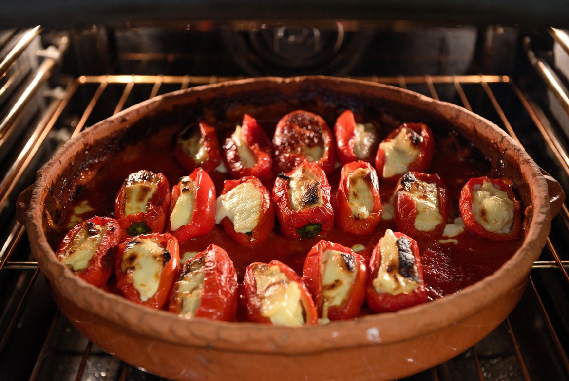 Pimientos del piquillo rellenos en el horno, gratinándose con queso.