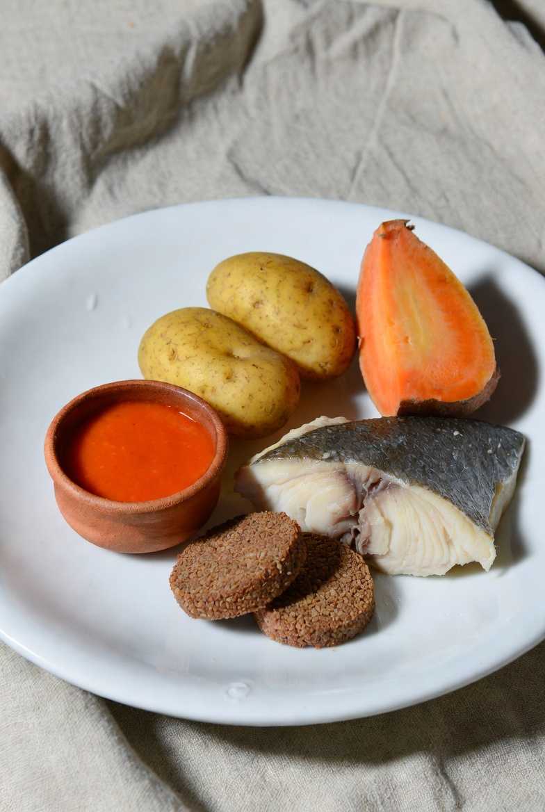 Plato presentado de sancocho canario tradicional con pescado, papas, batata, pella de gofio y mojo.