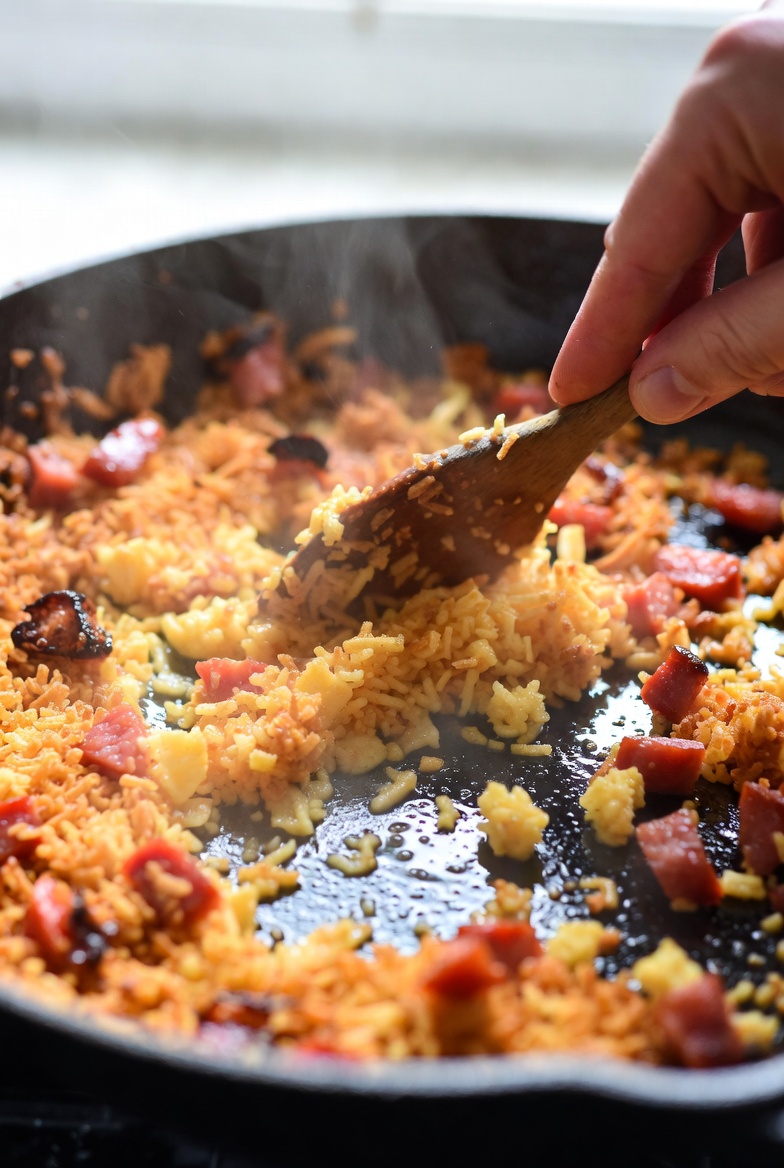 Proceso de tostado de migas manchegas con chorizo en sart&eacute;n, mostrando su textura crujiente
