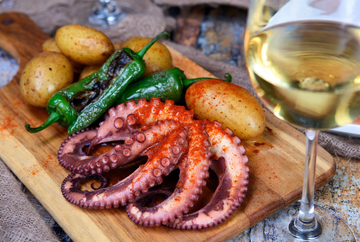 Pulpo a la plancha con piment&oacute;n servido con cachelos, pimientos de padr&oacute;n y una copa de Albari&ntilde;o.