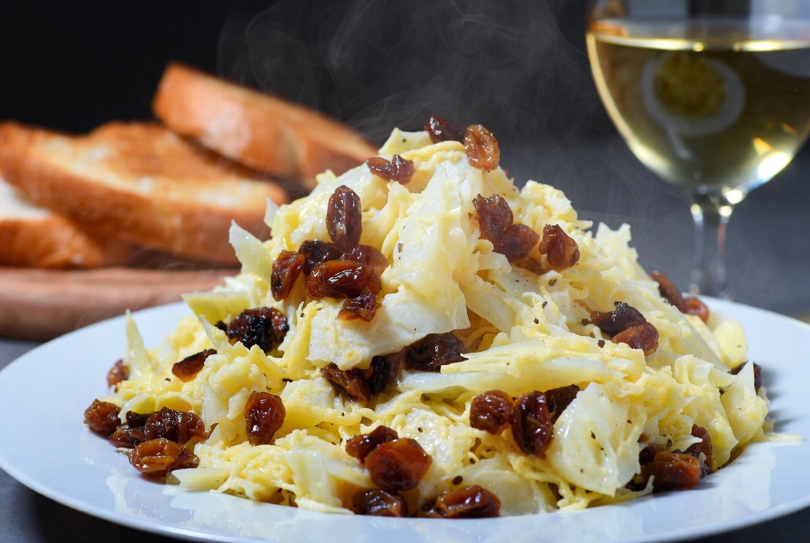 Revuelto de bacalao y pasas terminado, cremoso y listo para servir como plato principal.