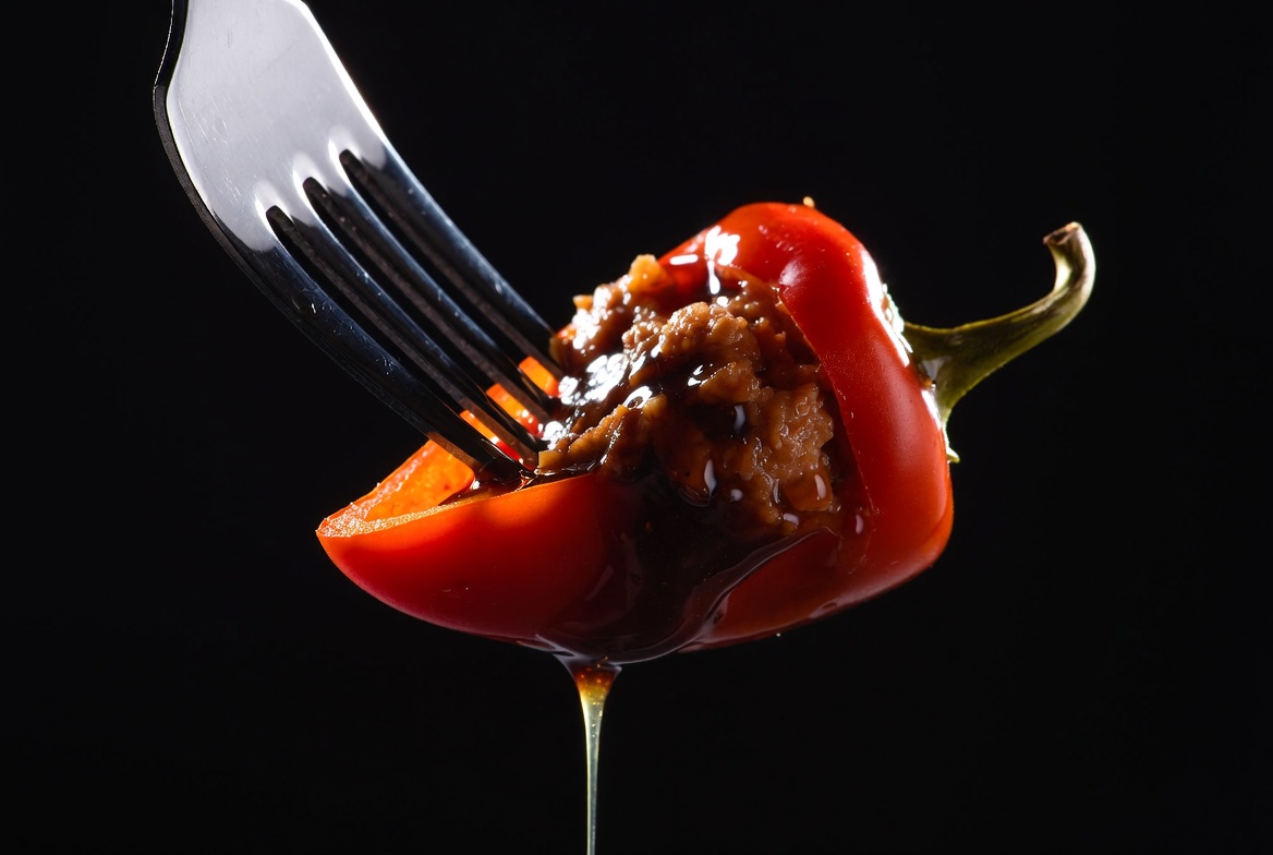 Detalle macro del corte de un pimiento del piquillo relleno mostrando su interior jugoso