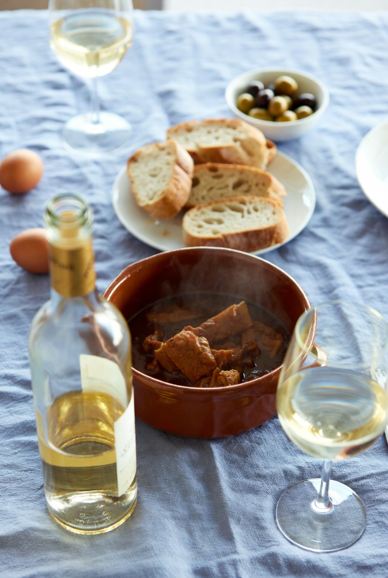 Potaje de vigilia en mesa con vino blanco, pan y acompa&ntilde;amientos, listo para comer