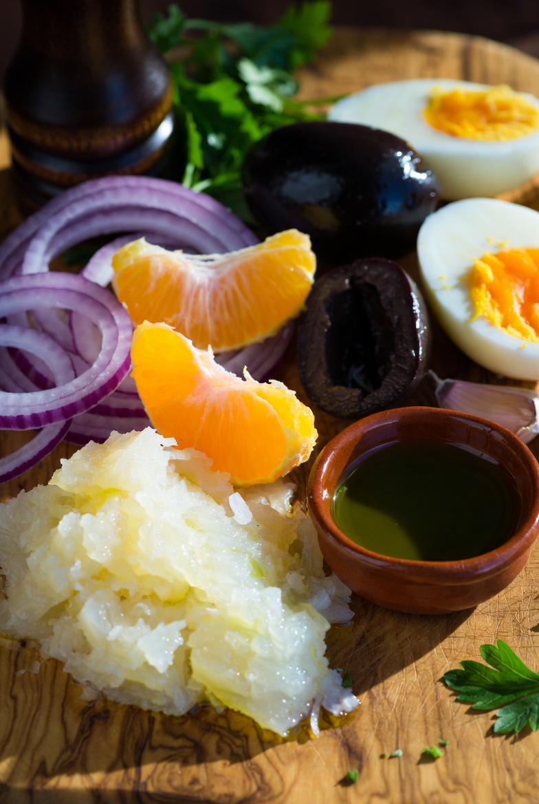 Ingredientes frescos para un Remoj&oacute;n Andaluz tradicional sobre tabla de madera de olivo