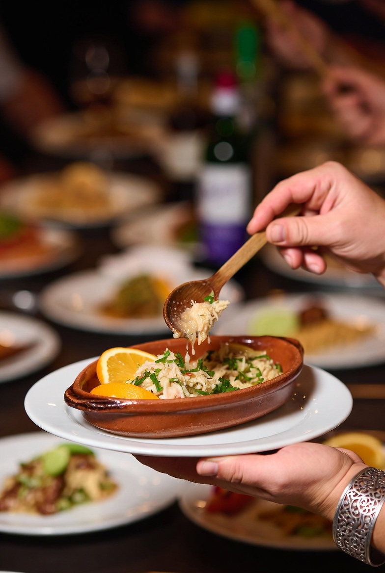 Momento de servir una porci&oacute;n de Remoj&oacute;n Andaluz en un plato individual