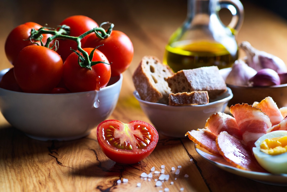 Ingredientes frescos para hacer salmorejo cordob&eacute;s: tomate, pan, ajo, jam&oacute;n y huevo
