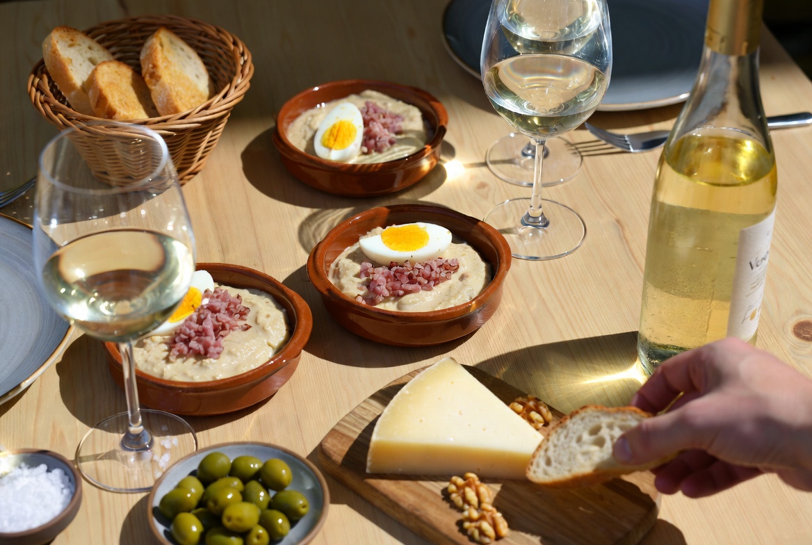 Mesa con salmorejo cordob&eacute;s, vino blanco, pan y aceitunas para una comida completa